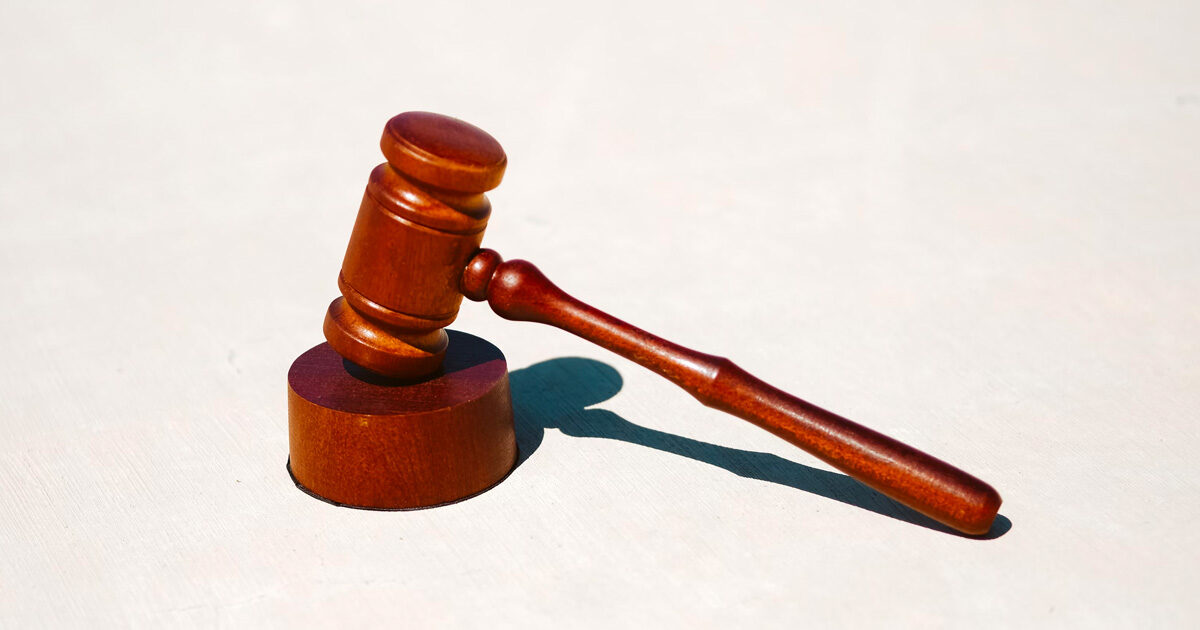 Wooden judges gavel and block on a white table background.