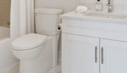 White, modern bathroom vanity, toilet, and bathtub/shower combo.
