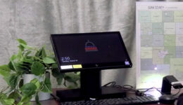 Badger Books voting election equipment setup on a desk next to a map of Dunn County, Wisconsin.