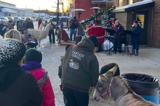 Community members gather in front of the public library to celebrate the Spirit Of Christmas festival in the Village of Boyceville, Wisconsin.