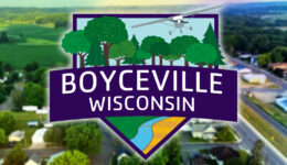 New logo for the Village of Boyceville, Wisconsin overlaid on a blurred photo of downtown Boyceville.